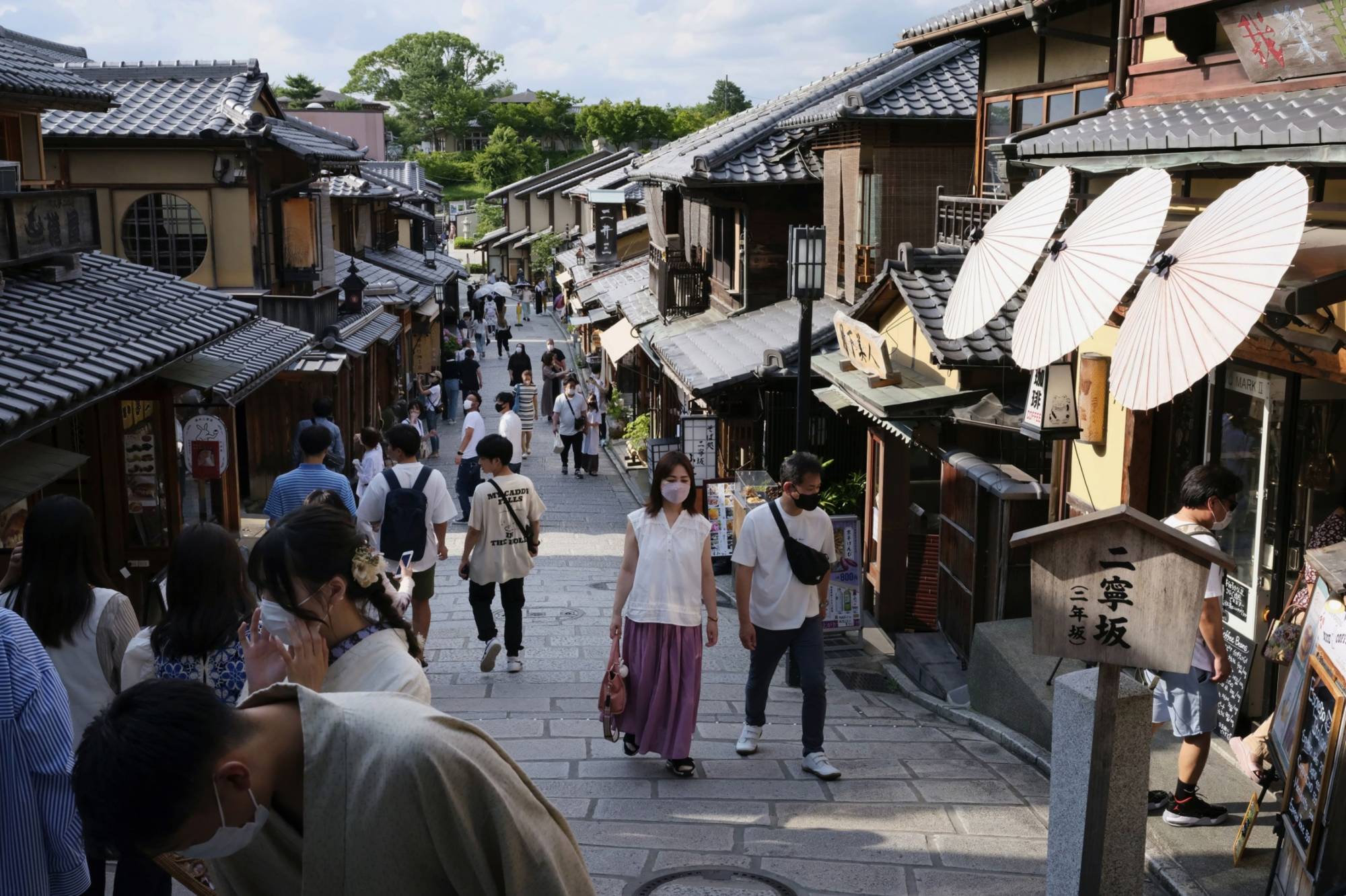 Visitors stroll along a commercial street in Kyoto. Domestic travel is booming as people enjoy their first restriction-free summer since 2019 and as still-tight border rules keep away the hordes of foreign visitors that typically crowd popular attractions. | BLOOMBERG