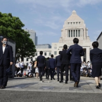 Lawmakers enter the parliament building grounds Wednesday. | KYODO