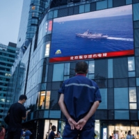 A news broadcast about joint military operations near Taiwan by the Chinese People\'s Liberation Army at a shopping center in Beijing on Wednesday | REUTERS