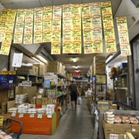 Price signs inside a grocery stall at the Hachioji Wholesale Center in Hachioji, Tokyo. Wholesale prices of beverages and foods rose 5.5% in July from a year earlier, accelerating from a 4.6% gain in June, highlighting the lingering impact of higher input costs. | BLOOMBERG