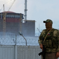 A serviceman stands guard near the Zaporizhzhia Nuclear Power Plant outside the Russian-controlled city of Enerhodar, in the Zaporizhzhia region of Ukraine, on Aug. 4. | REUTERS