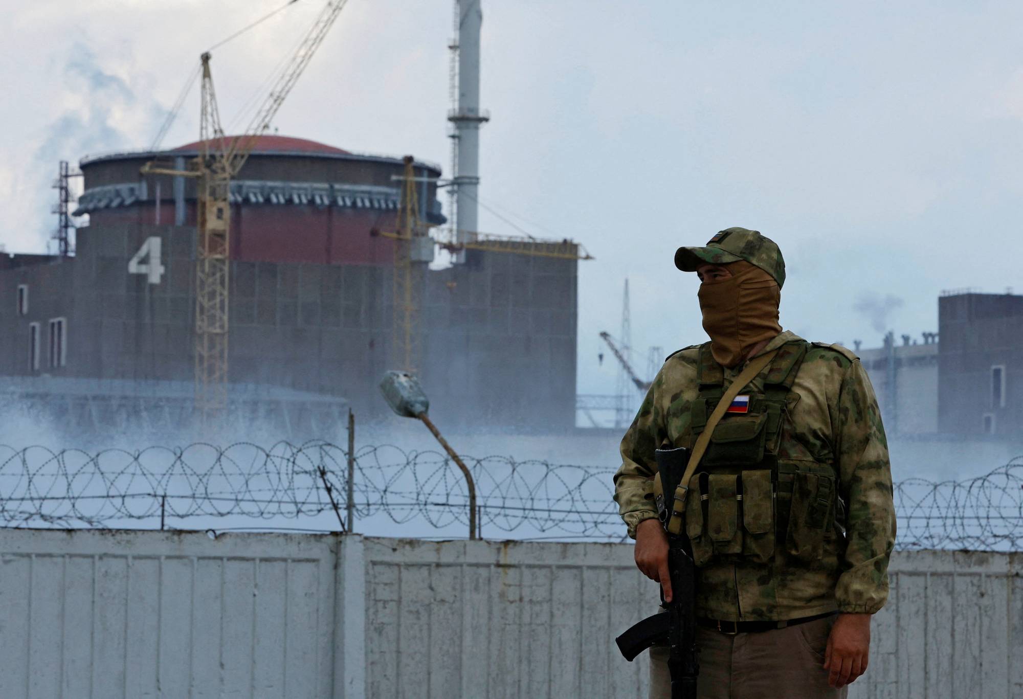 A serviceman stands guard near the Zaporizhzhia Nuclear Power Plant outside the Russian-controlled city of Enerhodar, in the Zaporizhzhia region of Ukraine, on Aug. 4. | REUTERS