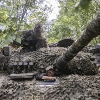 A Ukrainian soldier climbs out of a tank at a camouflaged frontline position after completing a mission in Kherson region of Ukraine, on July 28.  | DAVID GUTTENFELDER / THE NEW YORK TIMES
