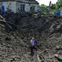 A man stands inside a crater left by a Russian missile strike in the settlement of Kushuhum, in Ukraine\'s Zaporizhzhia region, on Wednesday.  | REUTERS