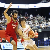 Japan\'s Yudai Baba (right) attacks the Iranian basket during the fourth quarter in Sendai on Sunday. | KYODO