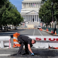 A U.S. Capitol Police officer works near a barricade on Capitol Hill in Washington on Sunday. A man died early Sunday after driving his car into the barricade and firing shots into the air before turning his gun on himself, police said. | AFP-JIJI