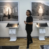 The Japanese photographer Tsukasa Yajima with portraits he took of former \"comfort women,\" or women who suffered under Japan’s military brothel system before and during World War II, at the history museum of the House of Sharing shelter, in Gwangju, South Korea, on July 3. Although Yajima has won praise for exposing problems at the shelter, he has also been the focus of intense backlash.  | WOOHAE CHO / THE NEW YORK TIMES