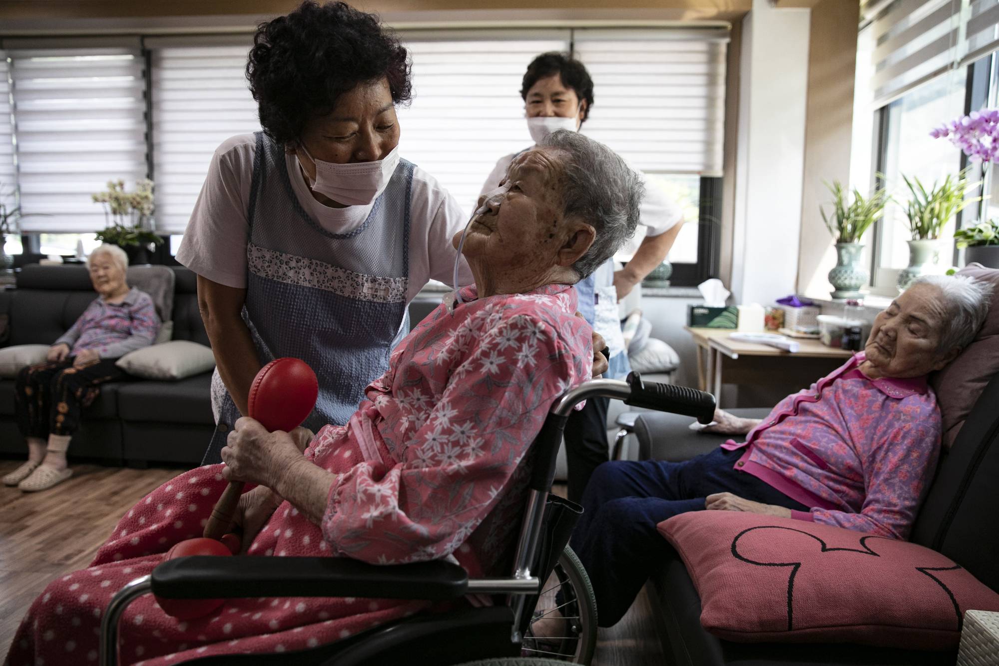 Park Ok-sun with a caregiver at the House of Sharing | Woohae Cho / The New York Times