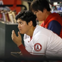 Angels star Shohei Ohtani watches from the bench after pitching six innings against the Mariners in Anaheim, California, on Monday. | KYODO