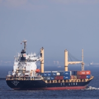 A container ship near a shipping terminal in Yokohama on July 18. Japan’s trade deficit hit a record high in July, adding headwinds to the nation\'s economic recovery. | BLOOMBERG