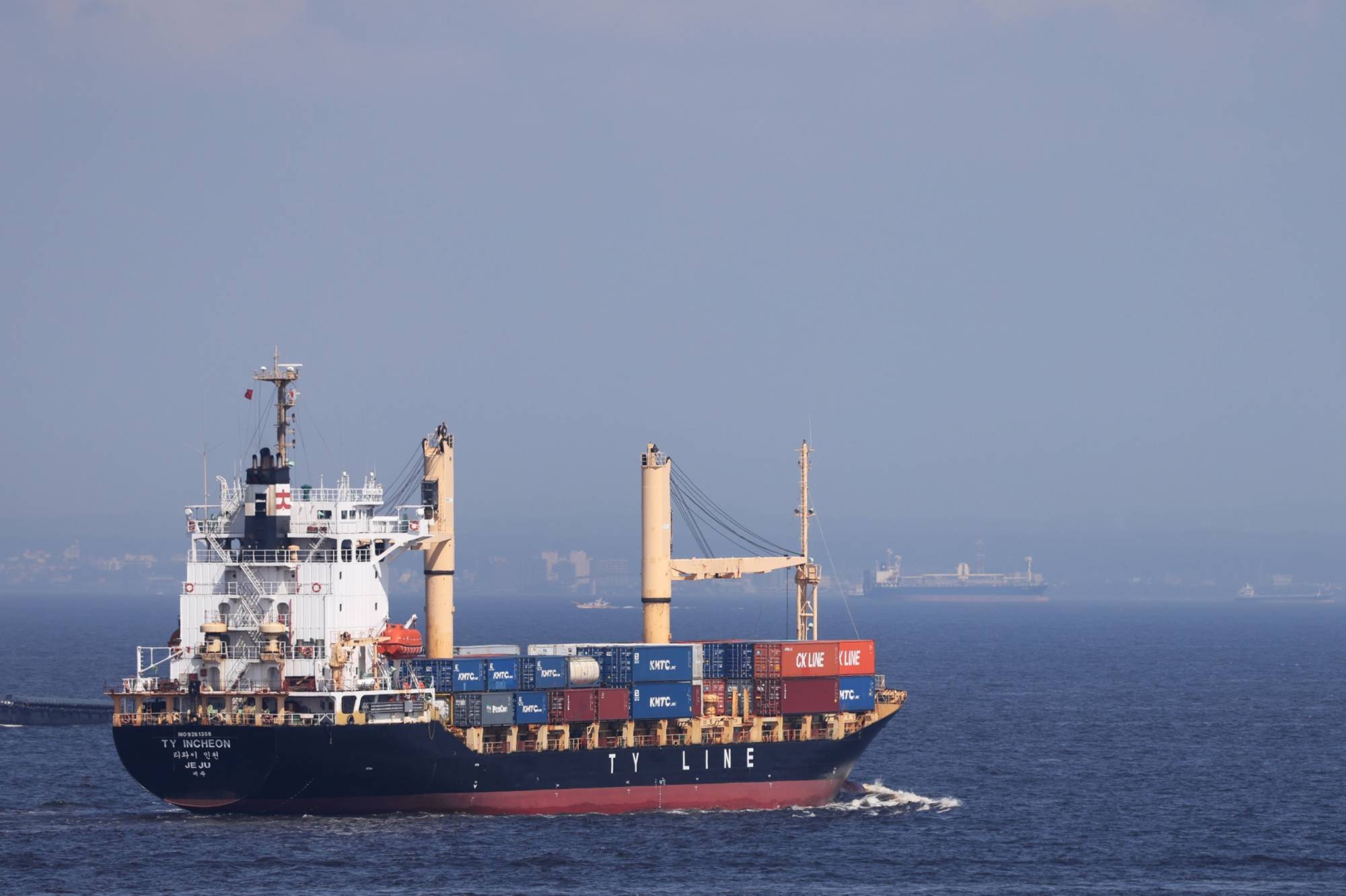 A container ship near a shipping terminal in Yokohama on July 18. Japan’s trade deficit hit a record high in July, adding headwinds to the nation's economic recovery. | BLOOMBERG