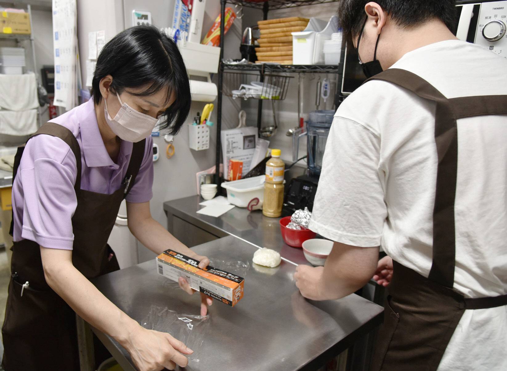Cafe owner Kana Oguri (left) cleans up with another staff member at a cafe in Aichi Prefecture. | CHUNICHI SHIMBUN