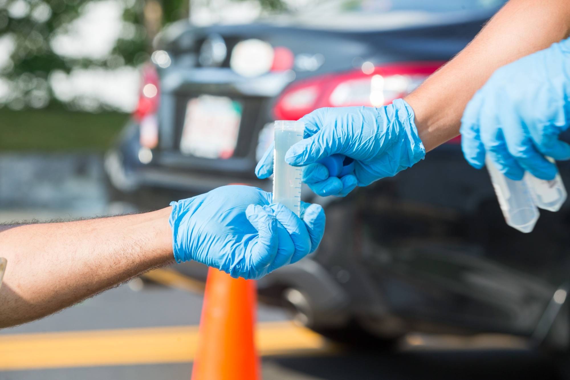 Workers in Massachusetts remove wastewater samples to test it for the coronavirus in July 2021. | BLOOMBERG