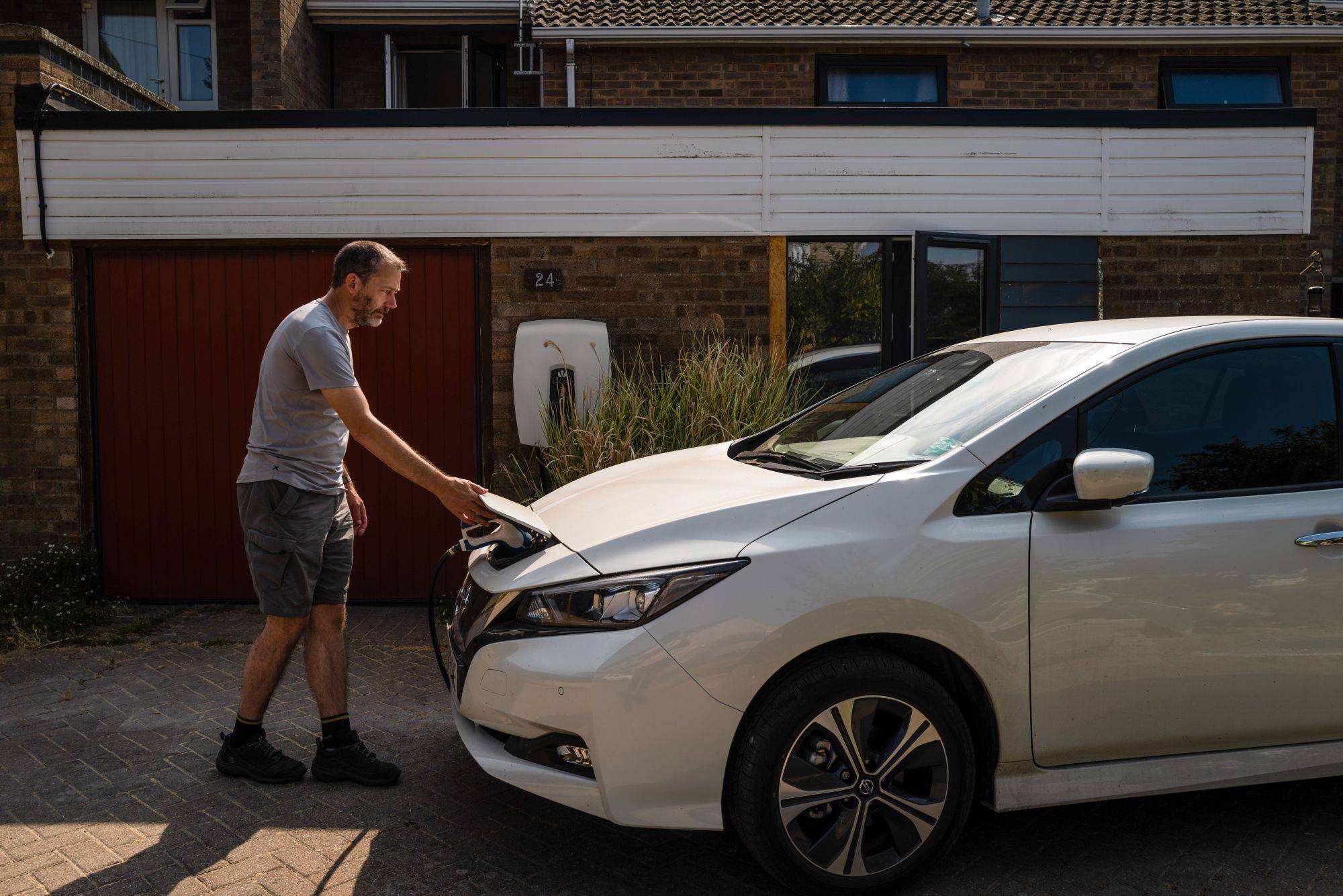 Paul Kershaw charges his a Nissan Leaf outside his home in Cambridge, England, on Aug. 15. | BLOOMBERG