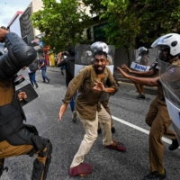 A Sri Lankan university student clashes with police during a demonstration in Colombo on Thursday.  | AFP-JIJI