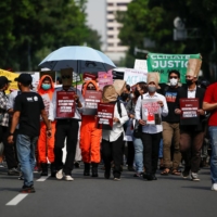 Activists carrying placards take part in a rally asking for climate justice in Jakarta in November 2021. | REUTERS