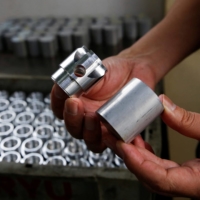 Hirotomi Kojima, CEO of Katsui Kogyo, holds components made at his factory in Higashiosaka, on June 23. | REUTERS