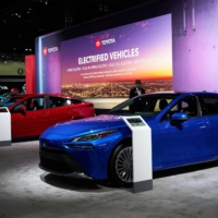 A 2022 Toyota Mirai hydrogen fuel-cell vehicle (right), next to Toyota Prius hybrid vehicles at the Los Angeles Auto Show in November 2021 | BLOOMBERG