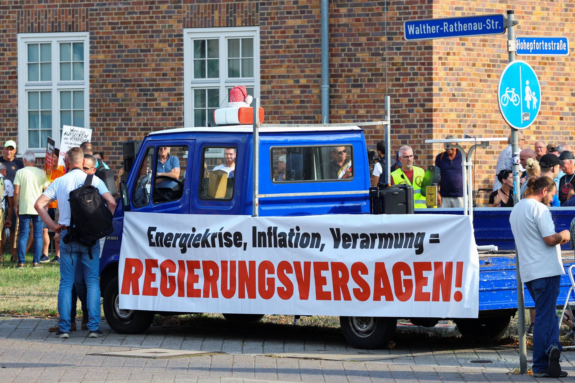 A banner reading 'energy crisis, inflation, impoverishment = government failure' is displayed on a vehicle as people protest during a visit by German Chancellor Olaf Scholz to a research laboratory at Magdeburg University, in Magdeburg, Germany, on Thursday. | REUTERS