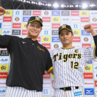 Tigers pitcher Junya Nishi (left) and catcher Seishiro Sakamoto pose during the postgame hero interview after their win over the BayStars in Osaka on Thursday. | KYODO
