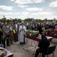 A funeral for a gay soldier and two other Ukrainian service members in May. The role of gay soldiers, the lack of legal rights for their partners, and the threat of Russia imposing anti-LGBTQ policies have turned the war into a catalyst for change in Ukraine. | NICOLE TUNG / THE NEW YORK TIMES