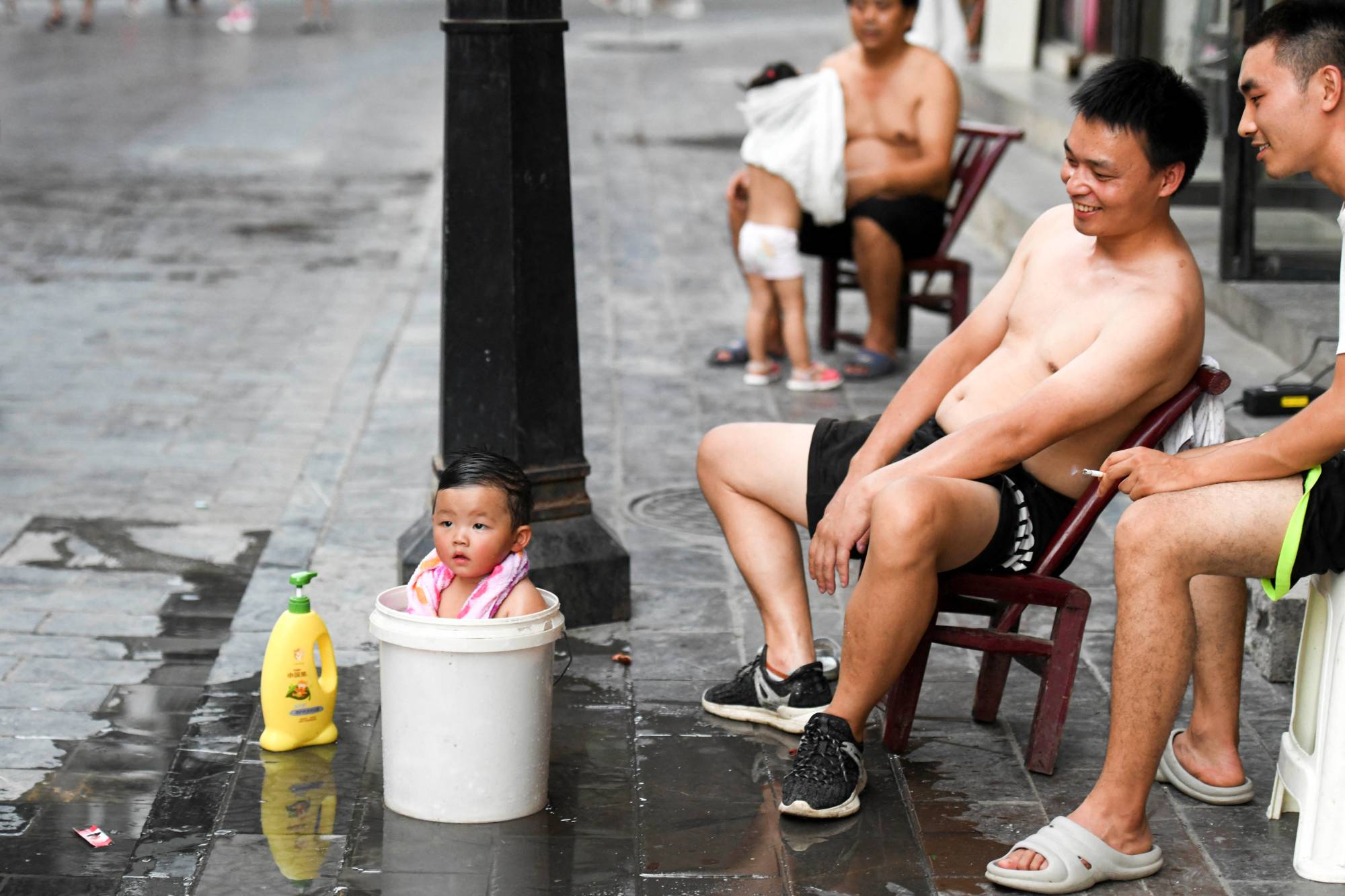 A child bathes in a bucket to cool off amid a heat wave warning in Huayuan county, in China's Hunan province, on Aug. 15. | cnsphoto / via REUTERS 