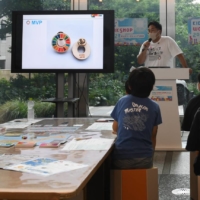 Logos promoting the United Nations’ Sustainable Development Goals campaign on screens at a workshop for children in Tokyo on Aug. 17. | NORIKO HAYASHI / THE NEW YORK TIMES