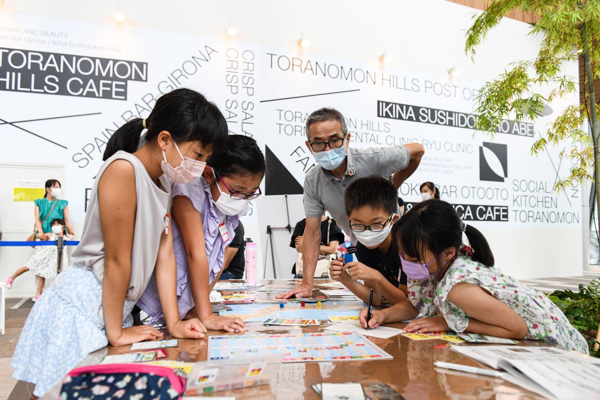 Children play a board game intended to familiarize them with the United Nations’ Sustainable Development Goals campaign in Tokyo on Aug. 17. | Noriko Hayashi / The New York Times