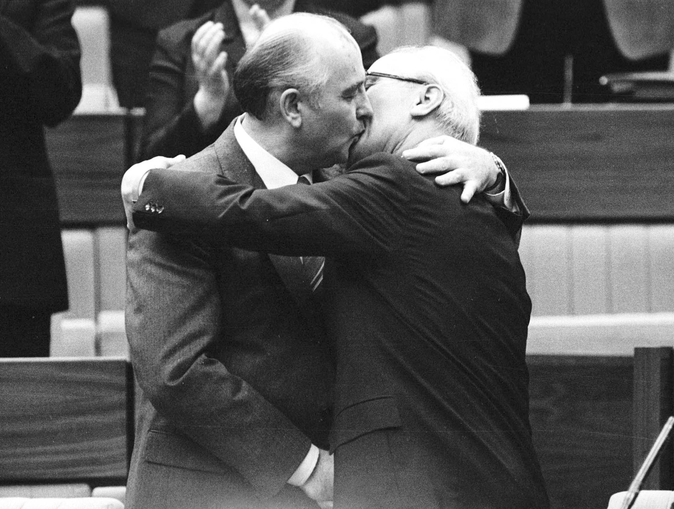 Soviet leader Mikhail Gorbachev (left) congratulates East German leader Erich Honecker with a fraternal hug and kiss after Honecker's re-election as general secretary of the Communist Party Congress in East Berlin in April 1986. | Gaby Sommer / REUTERS