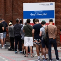 People line up to receive monkeypox vaccinations during a pop-up clinic at Guy\'s Hospital in central London on July 30. | REUTERS