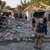 Police and military officers inspect destroyed houses in Mykolaiv, Ukraine, on Monday. | REUTERS
