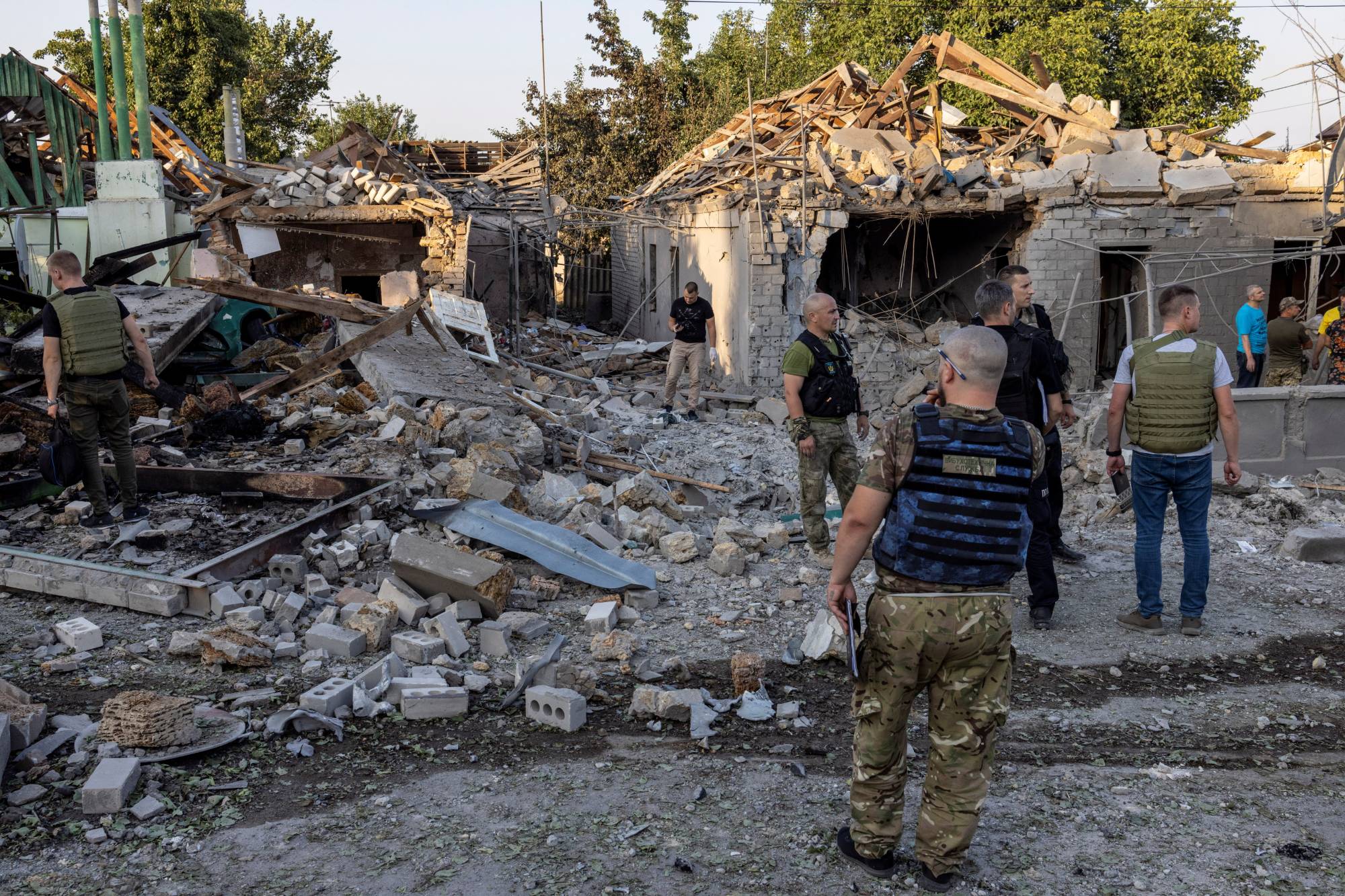 Police and military officers inspect destroyed houses in Mykolaiv, Ukraine, on Monday. | REUTERS
