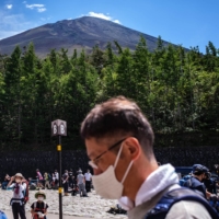 Tourists gather at bus terminals near Mount Fuji on Aug. 14. | AFP-JIJI