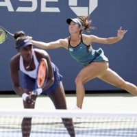 Ena Shibahara hits a shot behind partner Asia Muhammad during the first round of the women\'s doubles event at the U.S. Open on Wednesday. The pair defeated Russia\'s Varvara Gracheva and Poland\'s Katarzyna Piter. | KYODO