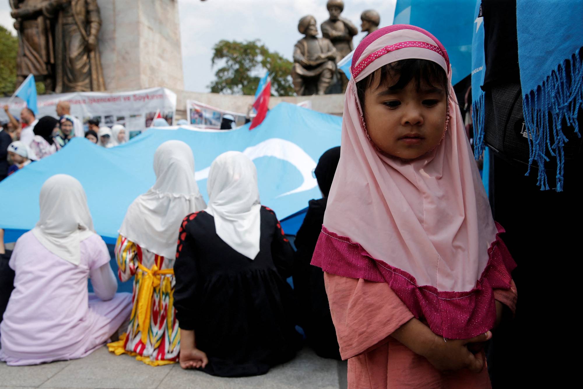 Ethnic Uyghur girls attend a protest in Istanbul against China on Thursday. | REUTERS