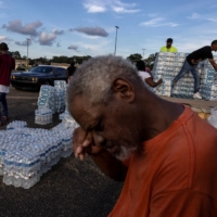 A Jackson, Mississippi, resident takes a break as he helps volunteers with the distribution of water bottles on Wednesday.  | REUTERS