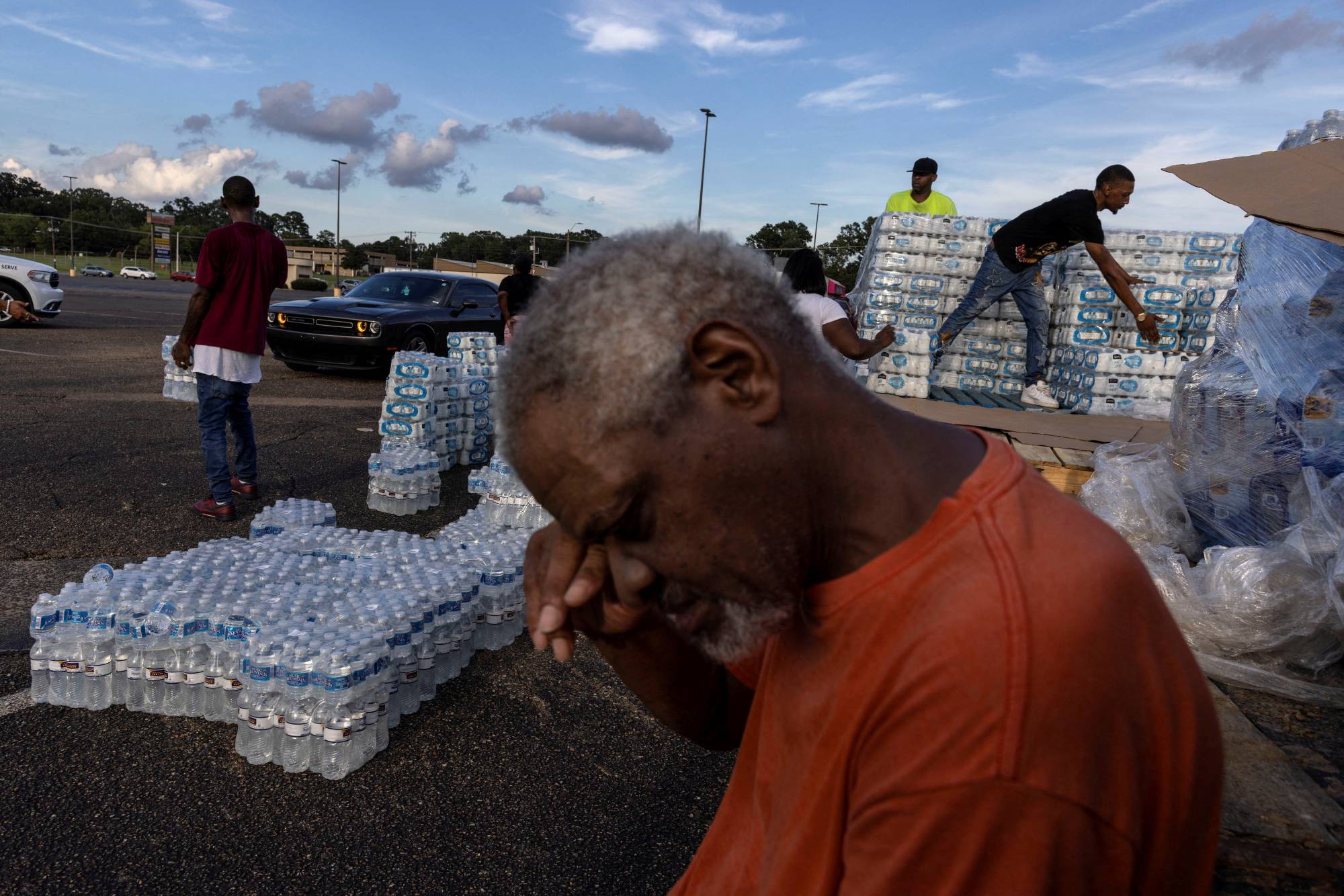 A Jackson, Mississippi, resident takes a break as he helps volunteers with the distribution of water bottles on Wednesday. | Reuters