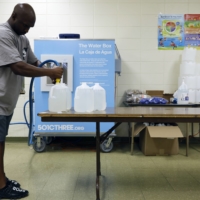 A man fills jugs of purified water for local residents in Jackson, Mississippi, on Tuesday.  | EDMUND FOUNTAIN / THE NEW YORK TIMES