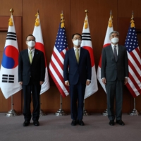 Kim Gunn, South Korea\'s new special representative for Korean Peninsula peace and security affairs, and his U.S. counterpart, Sung Kim, and Japanese counterpart, Takehiro Funakoshi, pose for photographs before a meeting at the Foreign Ministry in Seoul in June. | POOL / VIA REUTERS