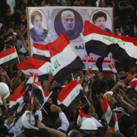 Supporters of Iraq\'s Coordination Framework lift a placard depicting top Shiite cleric Grand Ayatollah Ali al-Sistani (left) and past leaders during a rally in Baghdad on Aug. 12.  | AFP-JIJI