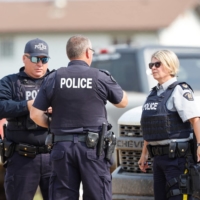 Royal Canadian Mounted Police officers at James Smith Cree Nation talk after multiple people were killed and injured in a stabbing spree on the reserve and nearby town of Weldon, Saskatchewan, Canada, on Monday. | REUTERS