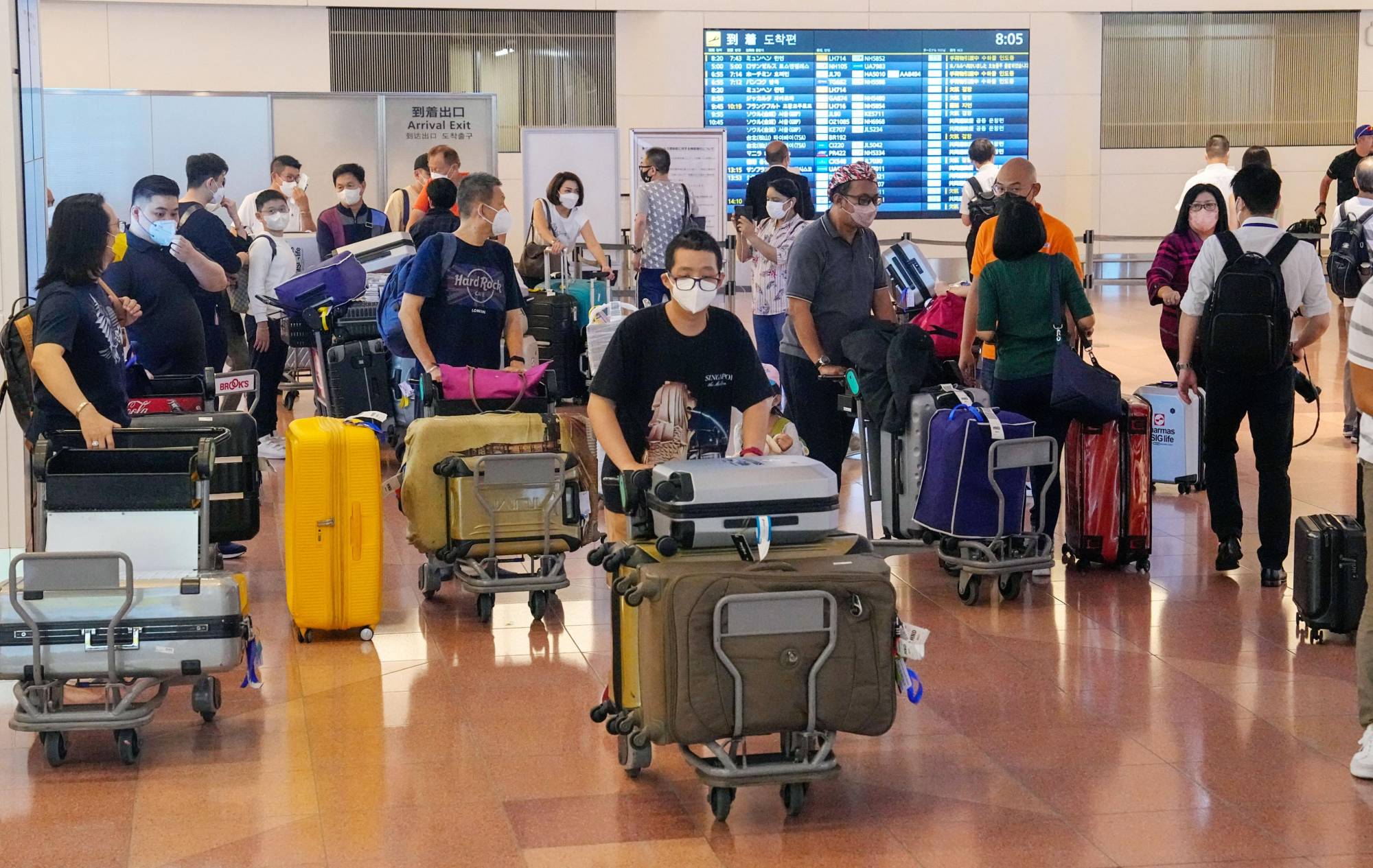 Passengers arrive at Tokyo's Haneda Airport on Wednesday morning. Starting Wednesday, travelers don't need to take pre-arrival PCR tests as part of eased border restrictions. | KYODO