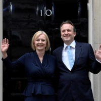 New British Prime Minister Liz Truss waves alongside her husband Hugh O\'Leary outside Downing Street in London, on Sep. 6. | REUTERS