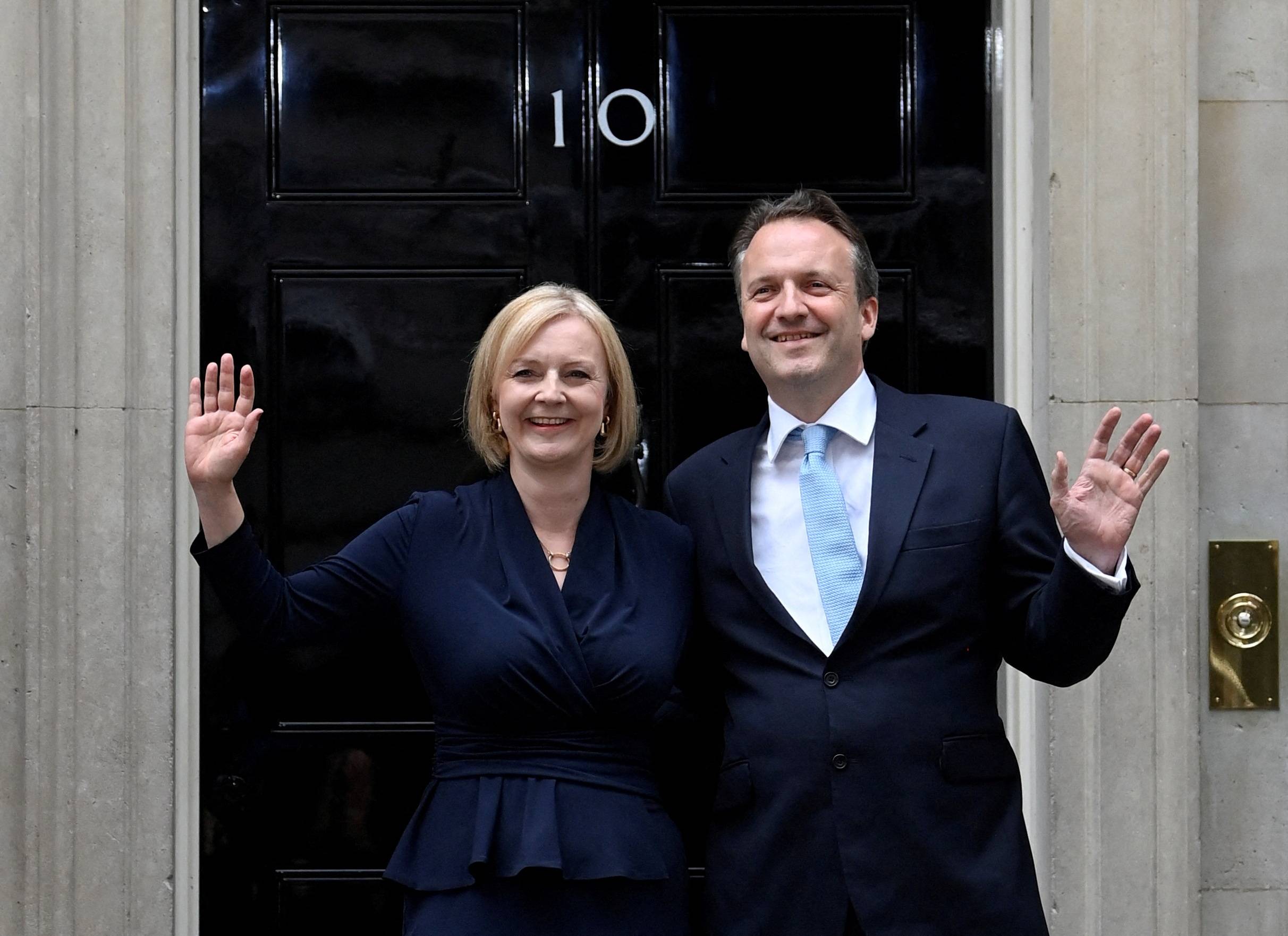 New British Prime Minister Liz Truss waves alongside her husband Hugh O'Leary outside Downing Street in London, on Sep. 6. | REUTERS