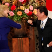 Then-international trade minister Liz Truss and then-Foreign Minister Toshimitsu Motegi bump elbows following a signing ceremony for the U.K.-Japan Comprehensive Economic Partnership Agreement in Tokyo in October, 2020. | REUTERS