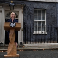 New British Prime Minister Liz Truss delivers remarks as her husband Hugh O\'Leary stands nearby at Downing Street, in London on Sep. 6. | REUTERS