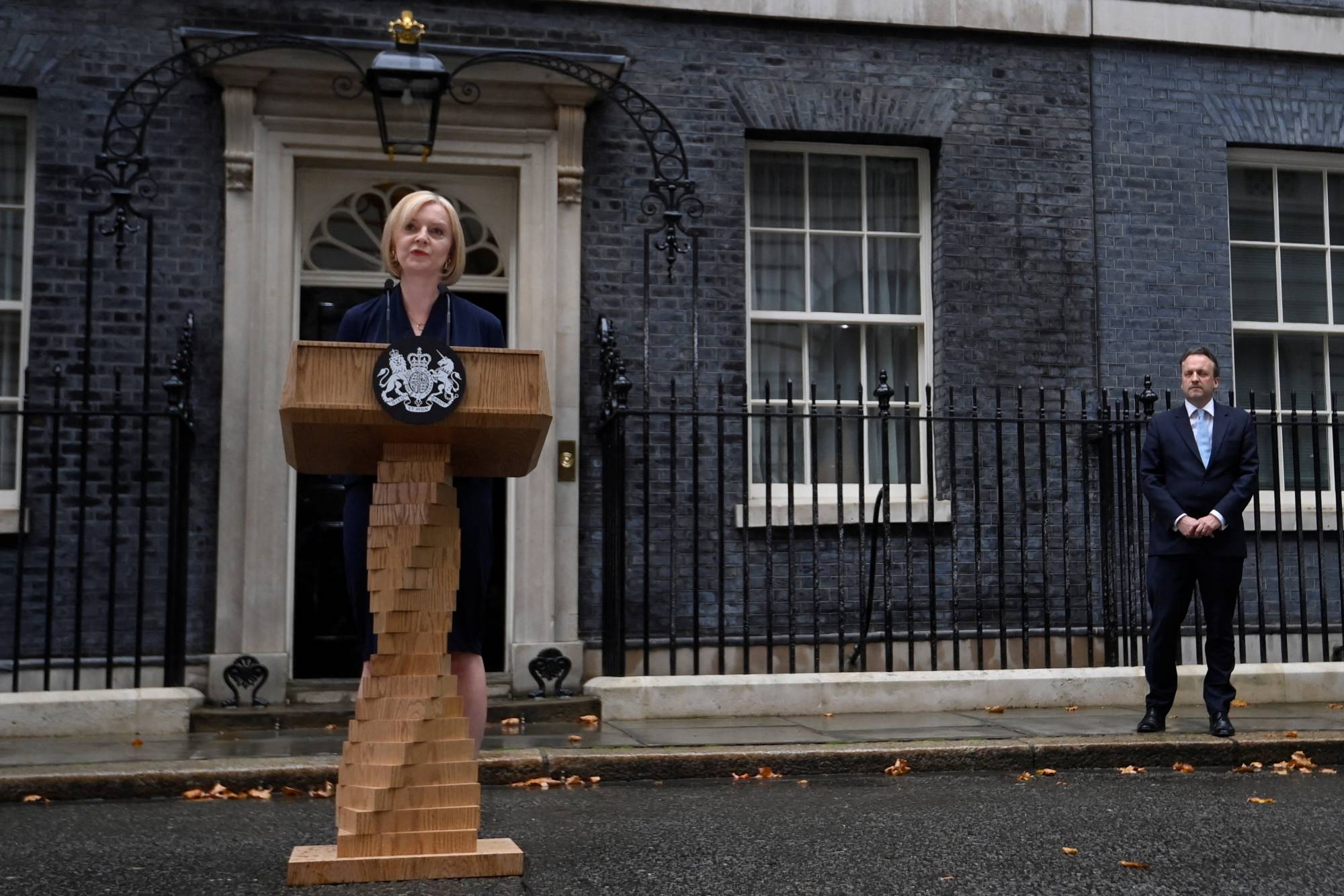 New British Prime Minister Liz Truss delivers remarks as her husband Hugh O'Leary stands nearby at Downing Street, in London on Sep. 6. | REUTERS