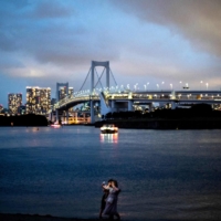 People pose for pictures at Odaiba Marine Park in Tokyo. | AFP-JIJI