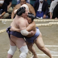 Tobizaru (right) grapples with yokozuna Terunofuji on Day 2 of the Autumn Grand Sumo Tournament at Ryogoku Kokugikan. | KYODO