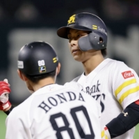 SoftBank\'s Kenta Imamiya (right) celebrates after driving in two runs against the Lions in Fukuoka on Monday. | KYODO